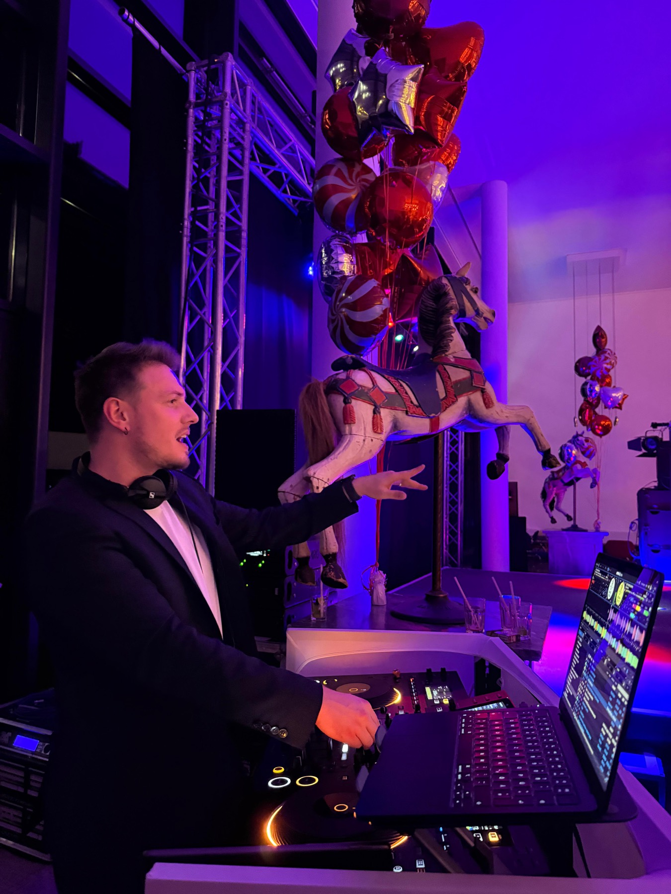 Phil bei einem Firmenabend im farbigen Licht, Luftballons über der Fläche