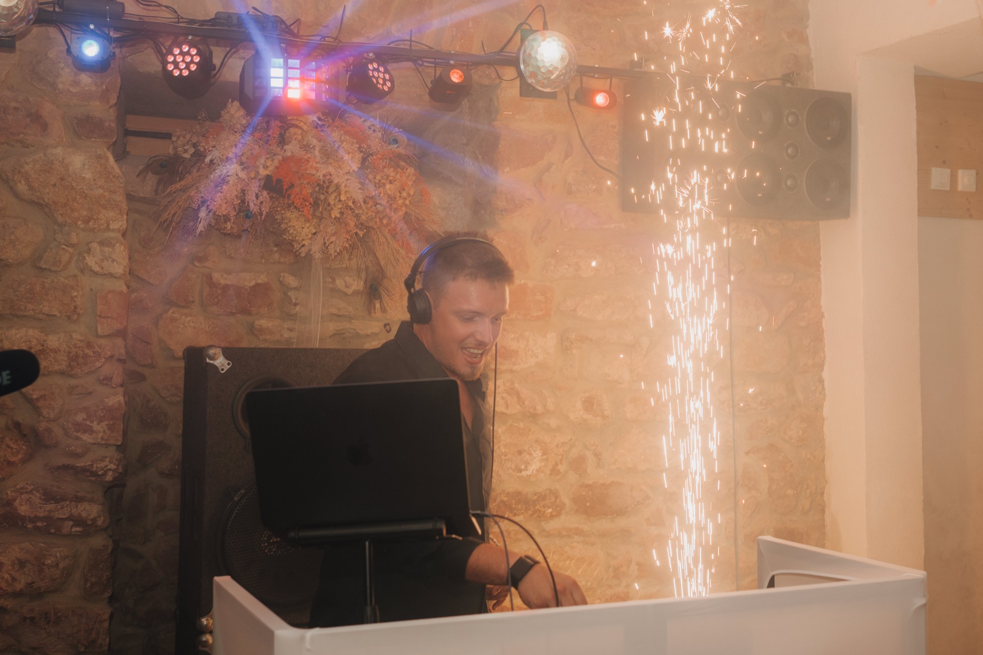 Phil am Pult mit Funkenfontäne, Discokugel und Licht über dem Steingewölbe